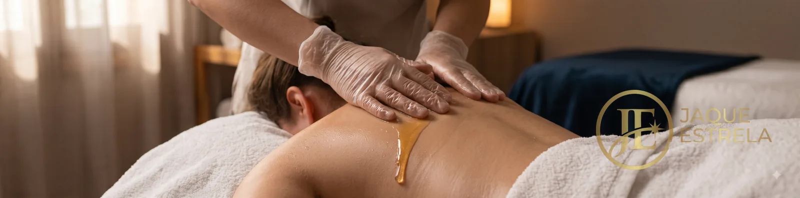 Banner: mãos da terapeuta em movimento, óleo essencial e ambiente em penumbra &mdash; alív