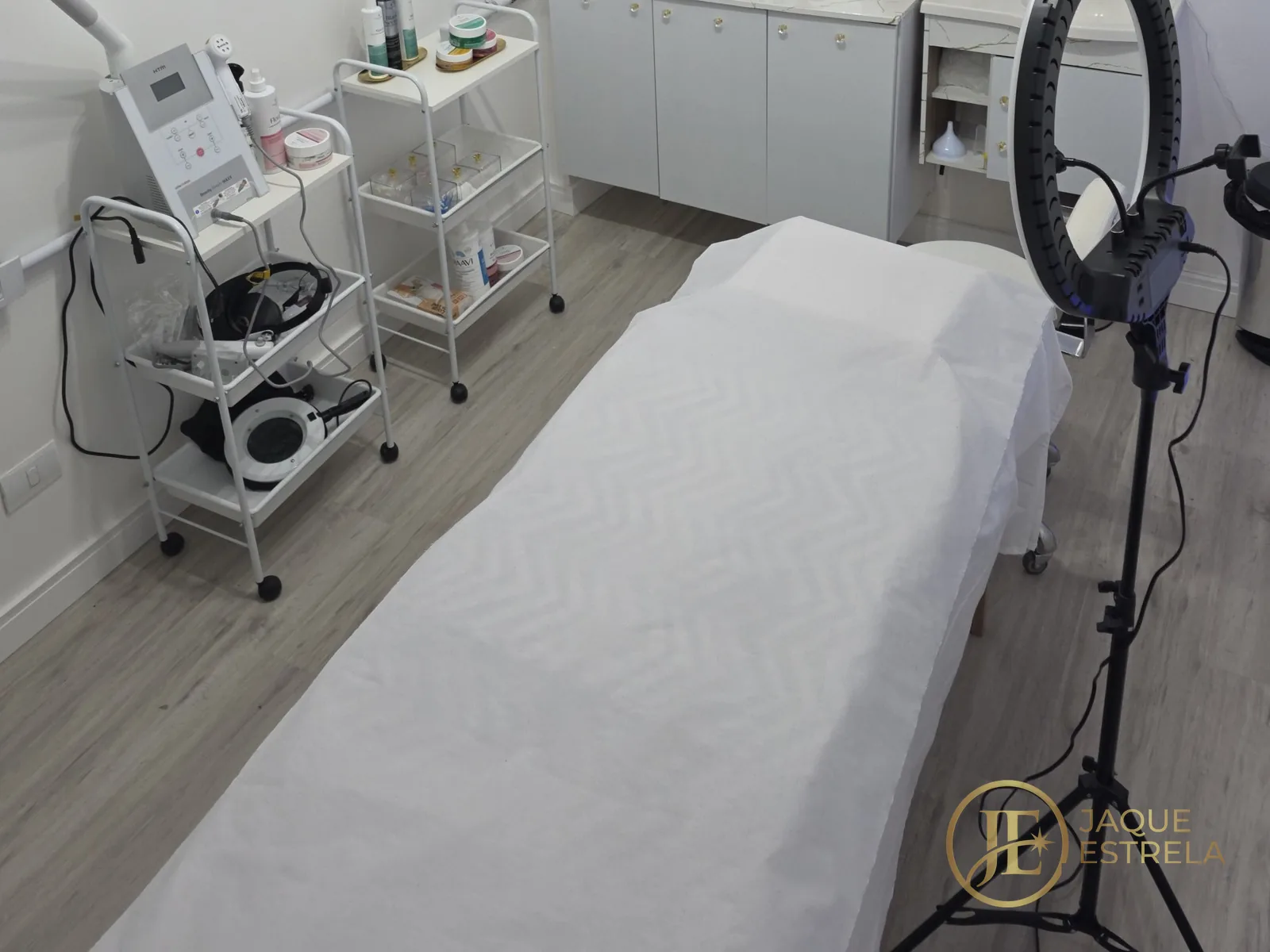 Nossa sala de verdade: maca com lençol descartável e carrinho de equipamentos