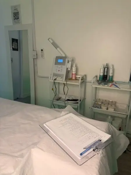 Sala de atendimento do estúdio com maca, aparelhos e ficha de anamnese